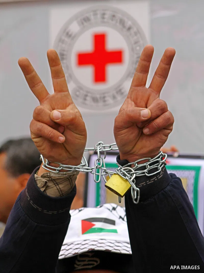 Palestinians man hold pictures of their prisoned relatives in Israeli jails as they gather in a weekly activity calling for their liberty at the Red Cross headquarters in Gaza City, on Jan. 23, 2012. Photo by Ashraf Amra
