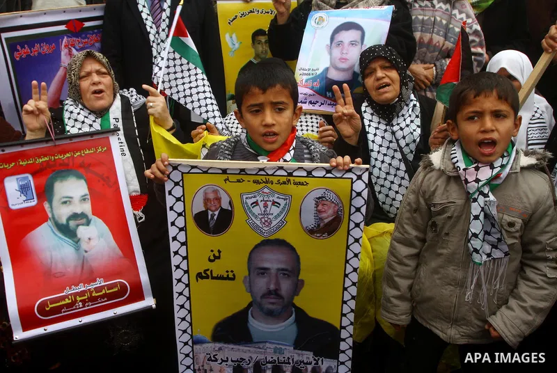 Palestinians man hold pictures of their prisoned relatives in Israeli jails as they gather in a weekly activity calling for their liberty at the Red Cross headquarters in Gaza City, on Jan. 23, 2012. Photo by Ashraf Amra