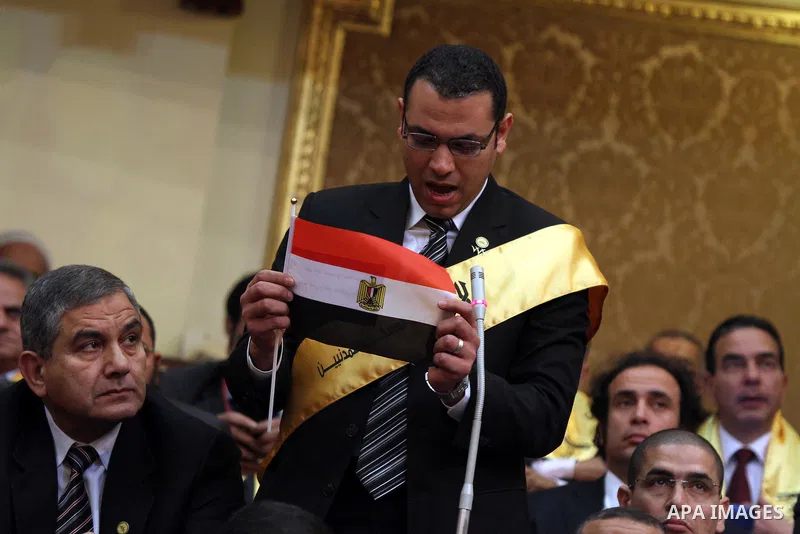 A member of the Egyptian parliament wears a banner reading "No to military trials" as parliament members attend the first Egyptian parliament session after the revolution that ousted former President Hosni Mubarak, in Ca...