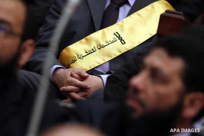 A member of the Egyptian parliament wears a banner reading "No to military trials" as parliament members attend the first Egyptian parliament session after the revolution that ousted former President Hosni Mubarak, in Ca...
