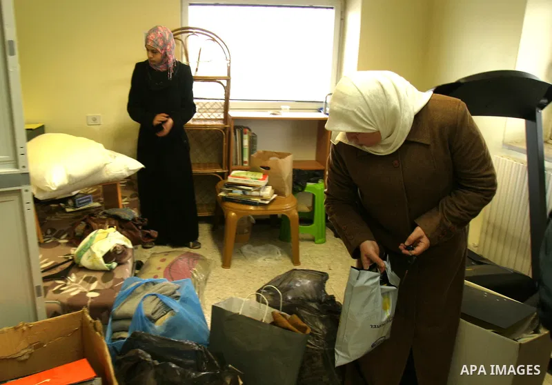 Relatives of Palestinian Khaled abu Arafeh and Mohammed Totah collect their belongings at the international Red Cross offices in east Jerusalem after Israeli police arrested on January 23, 2012 two senior Hamas officials...