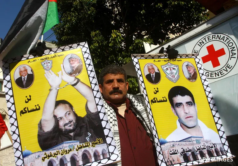Palestinian Jihad Islamic supporters hold pictures of prisoners in Israeli jails as they gather in a protest calling for their liberty at the Red Cross headquarters in Gaza City, on Jan. 24, 2012. Photo by Ashraf Amra