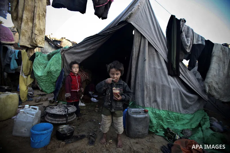 Palestinian children gather at their makeshift tent in one of the poorest regions in the Al-Zaiton neighbourhood, in the Gaza strip, on 24 January 2012. With high rates of unemployment and lack of work opportunities in G...