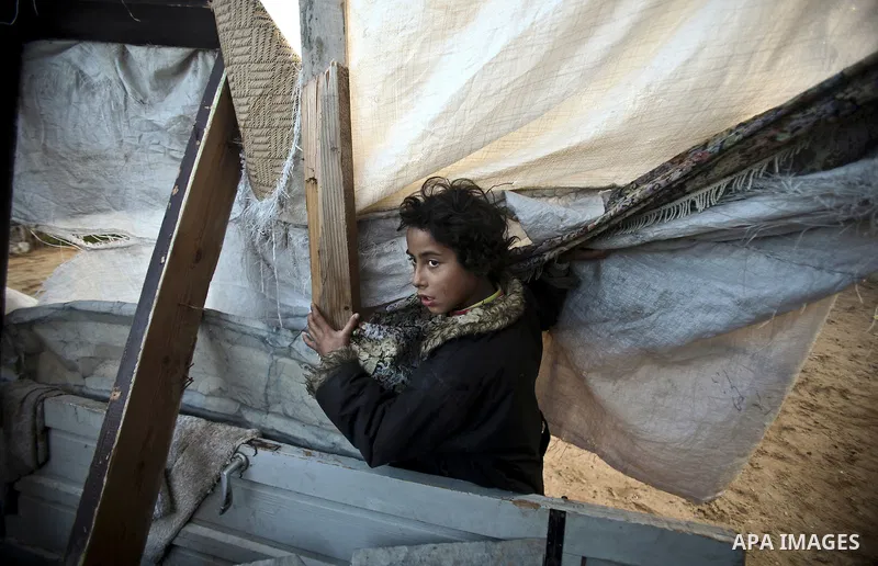 Palestinian children play between makeshift tents in one of the poorest regions in the Al-Zaiton neighbourhood, in the Gaza strip, on 24 January 2012. With high rates of unemployment and lack of work opportunities in Gaz...