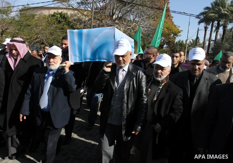 Palestinian Legislative Council members and other officials carry a mock coffin covered with the emblems of the International Committee of the Red Cross (ICRC) and the United Nations Relief and Works Agency (UNRWA) durin...