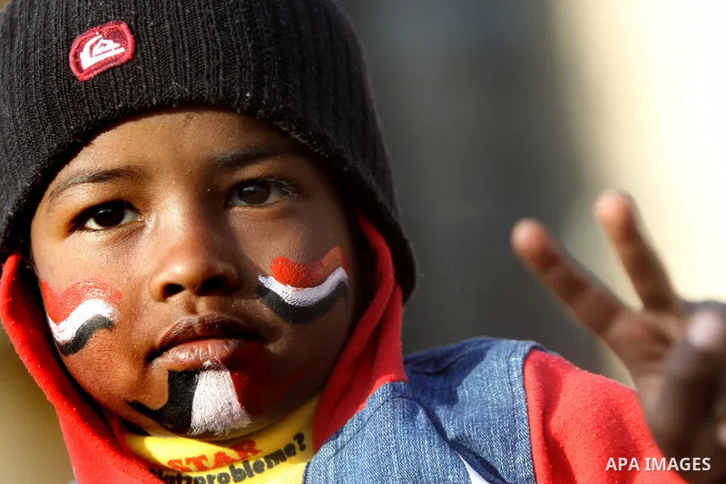An Egyptian boy paints his face with the national flag during a protest to celebrate the one year anniversary of the 25th January uprising at Tahrir square in Cairo, Egypt, 25 January 2012. One year earlier the same day...