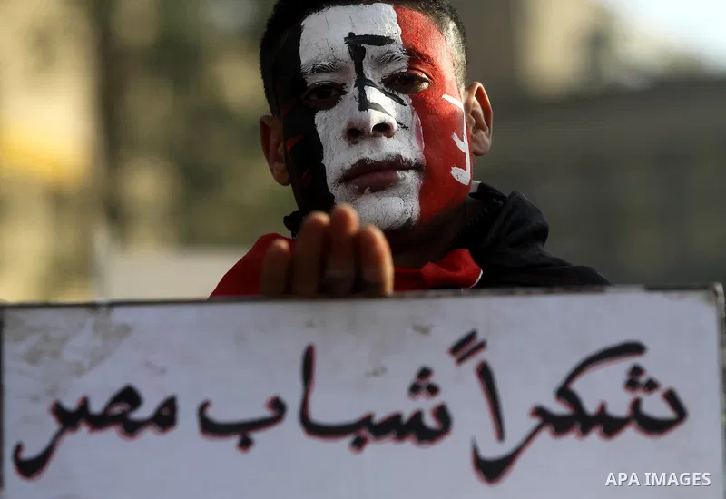 An Egyptian boy paints his face with the national flag during a protest to celebrate the one year anniversary of the 25th January uprising at Tahrir square in Cairo, Egypt, 25 January 2012. One year earlier the same day...