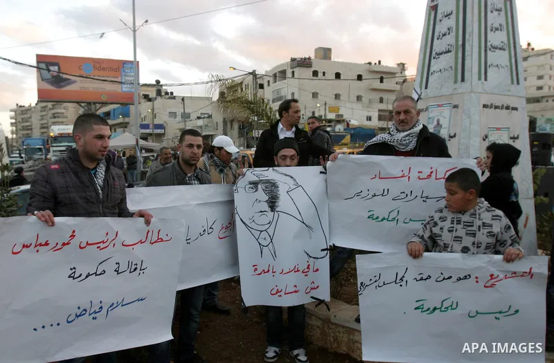 Palestinians demonstrate in Al-Azariya, on the outskirts of Jerusalem, to protest the high cost of living and against recent austerity measures announced by Palestinian prime minister Salam Fayyad (on poster) on January...