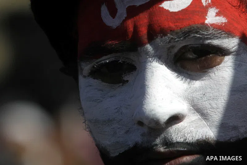 An Egyptian protester with his face painted in the colours of his national flag takes part in a protest demanding the army to hand power to civilians at Tahrir square in Cairo on January 27, 2012, a year after a popular...