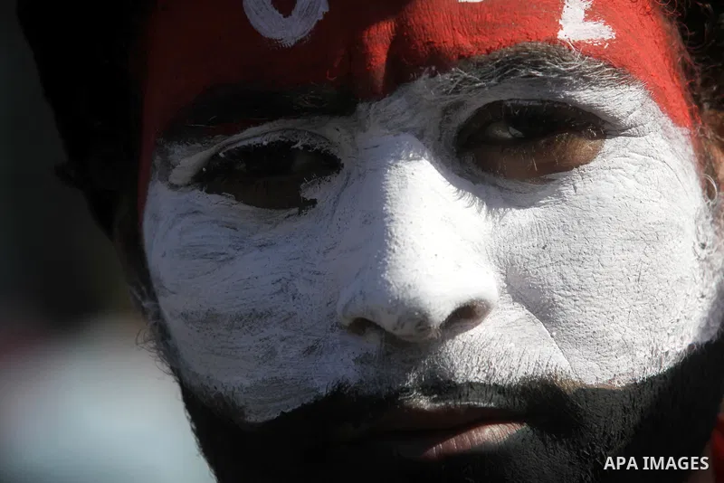 An Egyptian protester with his face painted in the colours of his national flag takes part in a protest demanding the army to hand power to civilians at Tahrir square in Cairo on January 27, 2012, a year after a popular...