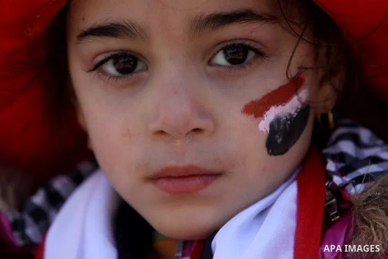 An Egyptian girl with her face painted in the colours of her national flag takes part in a protest demanding the army to hand power to civilians at Tahrir square in Cairo on January 27, 2012, a year after a popular upris...