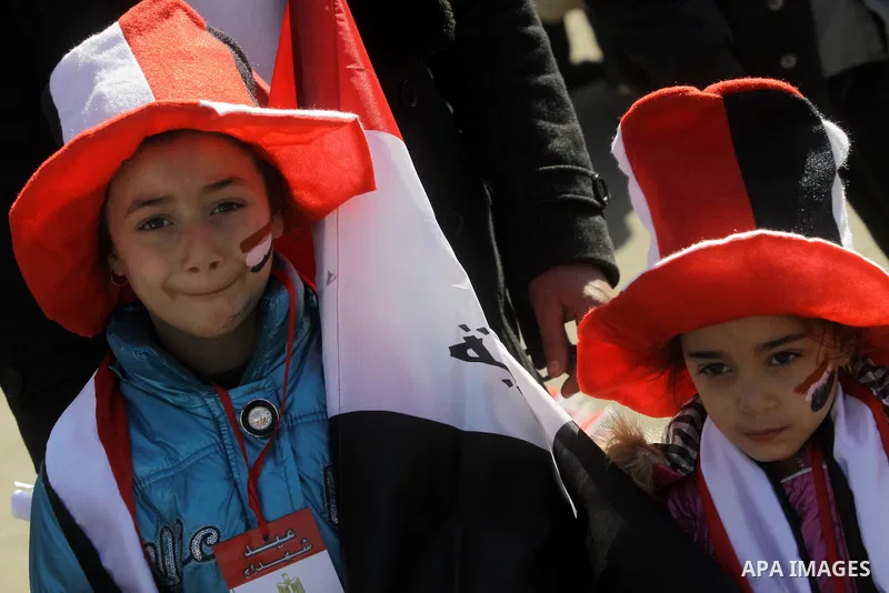 Egyptian girls with their face painted in the colours of their national flag takes part in a protest demanding the army to hand power to civilians at Tahrir square in Cairo on January 27, 2012, a year after a popular upr...