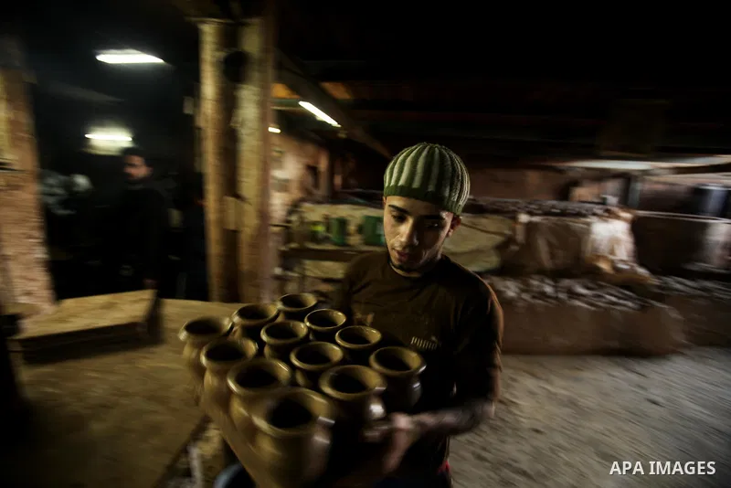 A Palestinian pottery workers spin a pot on a spin wheel at a pottery workshop in Gaza City on Jan 29. 2012. Pottery is a very ancient and traditional industry in Gaza City. Photo by Ashraf Amra. Photo by Ashraf Amra