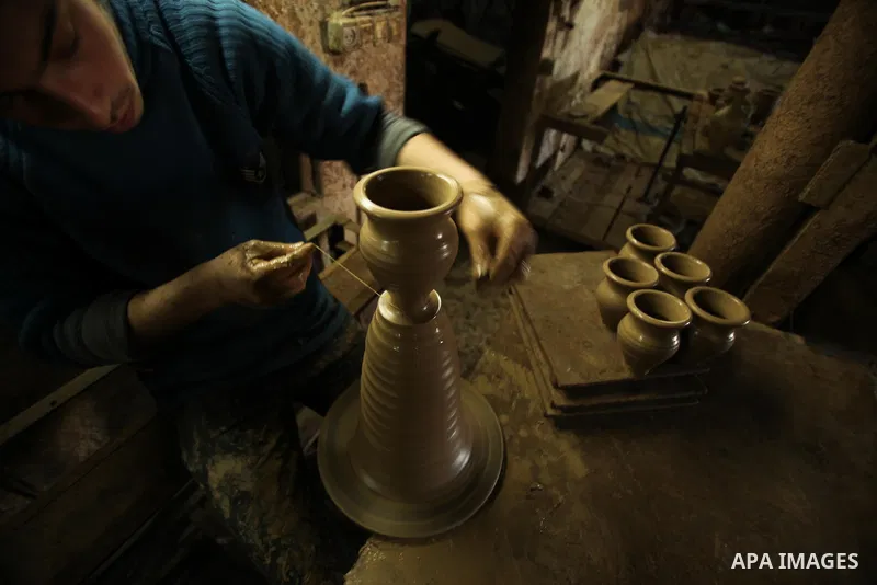 A Palestinian pottery workers spin a pot on a spin wheel at a pottery workshop in Gaza City on Jan 29. 2012. Pottery is a very ancient and traditional industry in Gaza City. Photo by Ashraf Amra. Photo by Ashraf Amra
