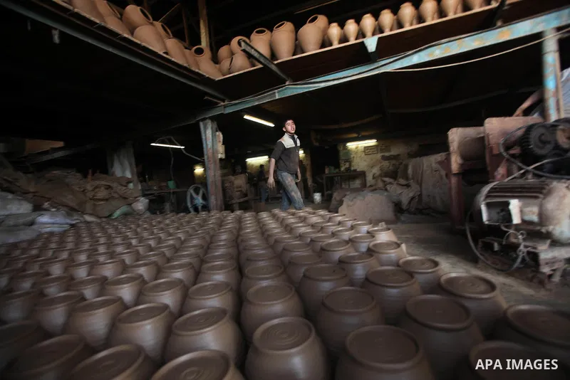 A Palestinian boy is standing in the middle of the earthenware vases at a pottery workshop in Gaza City on Jan 29. 2012. Pottery is a very ancient and traditional industry in Gaza City. Photo by Ashraf Amra