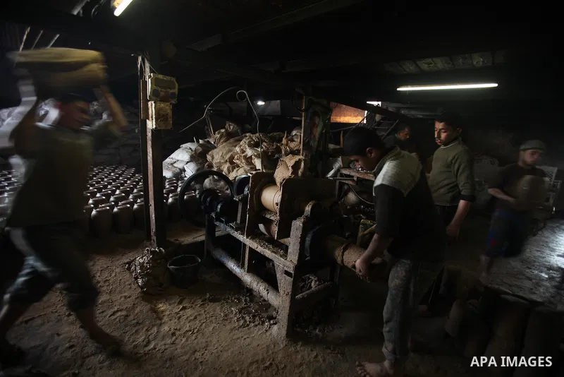 A Palestinian pottery workers spin a pot on a spin wheel at a pottery workshop in Gaza City on Jan 29. 2012. Pottery is a very ancient and traditional industry in Gaza City. Photo by Ashraf Amra. Photo by Ashraf Amra