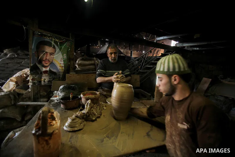 A Palestinian pottery workers spin a pot on a spin wheel at a pottery workshop in Gaza City on Jan 29. 2012. Pottery is a very ancient and traditional industry in Gaza City. Photo by Ashraf Amra. Photo by Ashraf Amra