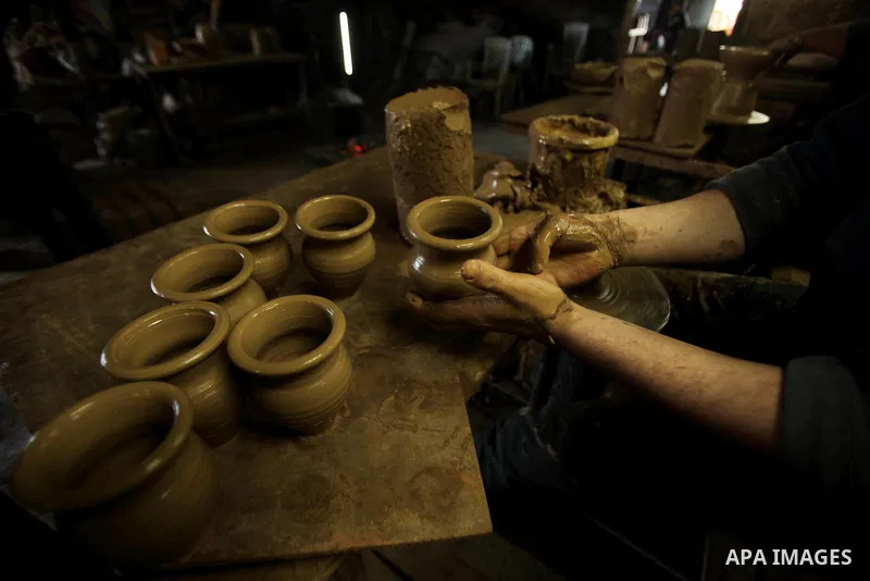 A Palestinian pottery workers spin a pot on a spin wheel at a pottery workshop in Gaza City on Jan 29. 2012. Pottery is a very ancient and traditional industry in Gaza City. Photo by Ashraf Amra. Photo by Ashraf Amra