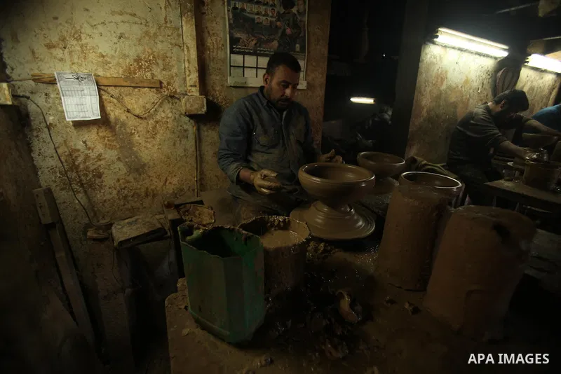 A Palestinian boy is standing in the middle of the earthenware vases at a pottery workshop in Gaza City on Jan 29. 2012. Pottery is a very ancient and traditional industry in Gaza City. Photo by Ashraf Amra