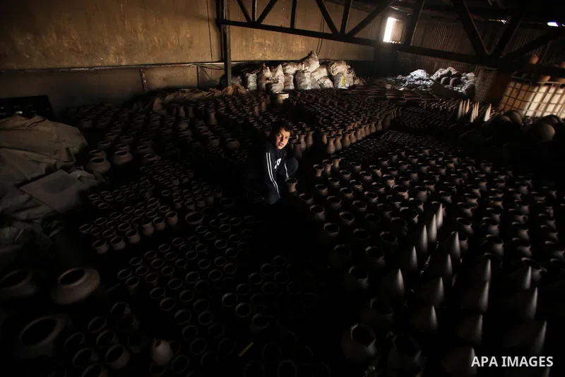 A Palestinian boy is standing in the middle of the earthenware vases at a pottery workshop in Gaza City on Jan 29. 2012. Pottery is a very ancient and traditional industry in Gaza City. Photo by Ashraf Amra