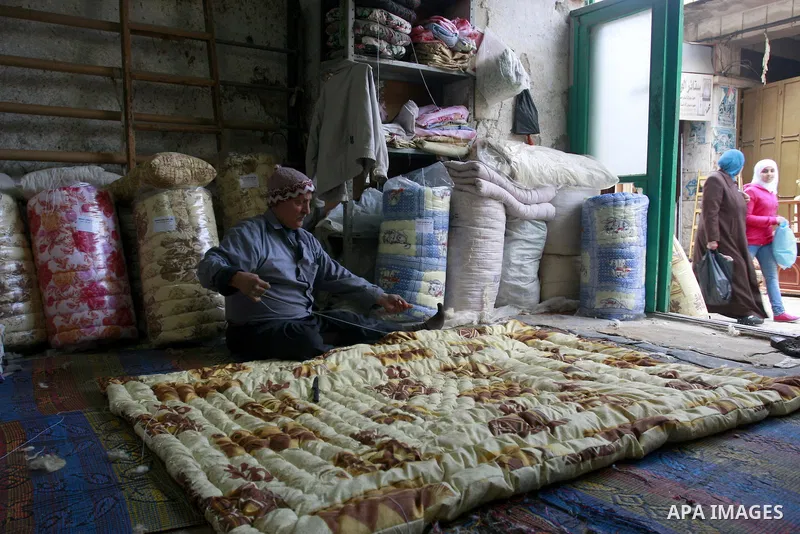 A Palestinian sews Quilt of the wool in his shop in the Old City, The West Bank city of Nablus on Monday , Jan , 29, 2012. and the industry is a quilt of traditional industries in Nablus. Photo by Wagdi Eshtayah