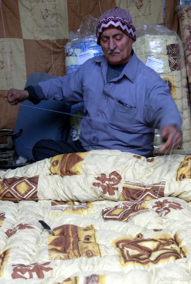 A Palestinian sews Quilt of the wool in his shop in the Old City, The West Bank city of Nablus on Monday , Jan , 29, 2012. and the industry is a quilt of traditional industries in Nablus. Photo by Wagdi Eshtayah