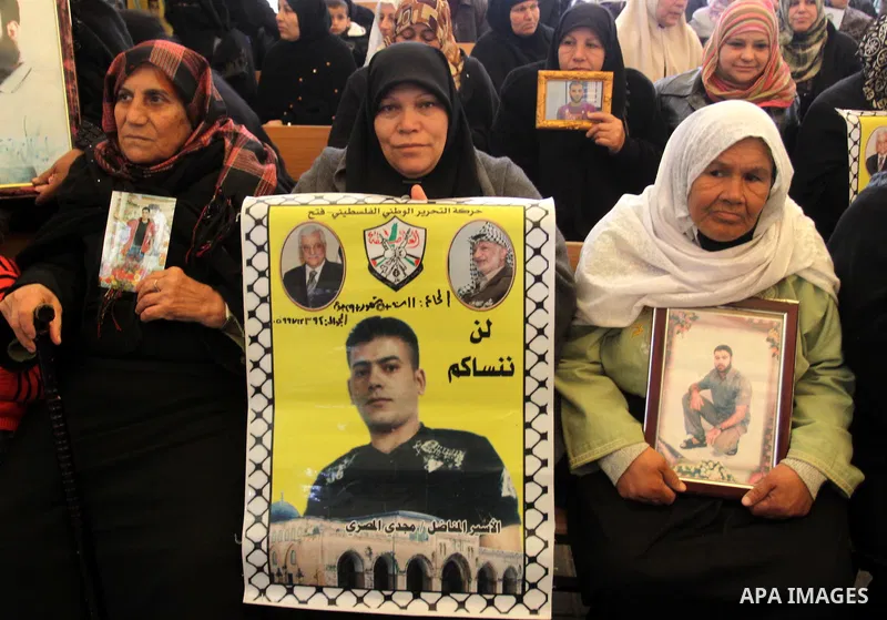 Palestinians hold pictures of their prisoned relatives in Israeli jails as they gather in a weekly activity calling for their liberty at the Red Cross headquarters in Gaza City, on Jan. 30, 2012. Photo by Mohammed Asad