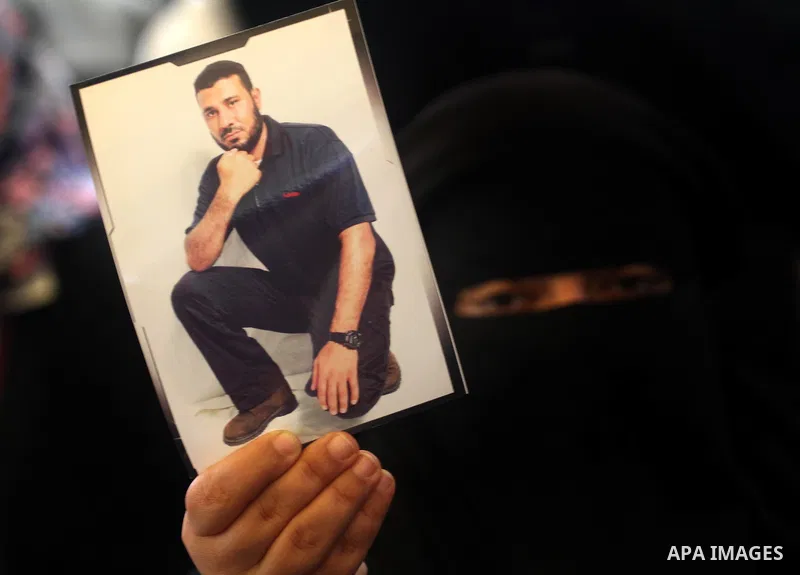 Palestinians hold pictures of their prisoned relatives in Israeli jails as they gather in a weekly activity calling for their liberty at the Red Cross headquarters in Gaza City, on Jan. 30, 2012. Photo by Mohammed Asad