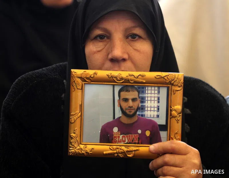Palestinians hold pictures of their prisoned relatives in Israeli jails as they gather in a weekly activity calling for their liberty at the Red Cross headquarters in Gaza City, on Jan. 30, 2012. Photo by Mohammed Asad