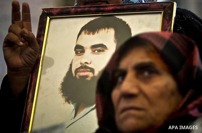 Palestinians hold pictures of their prisoned relatives in Israeli jails as they gather in a weekly activity calling for their liberty at the Red Cross headquarters in Gaza City, on Jan. 30, 2012. Photo by Ali Jadallah
