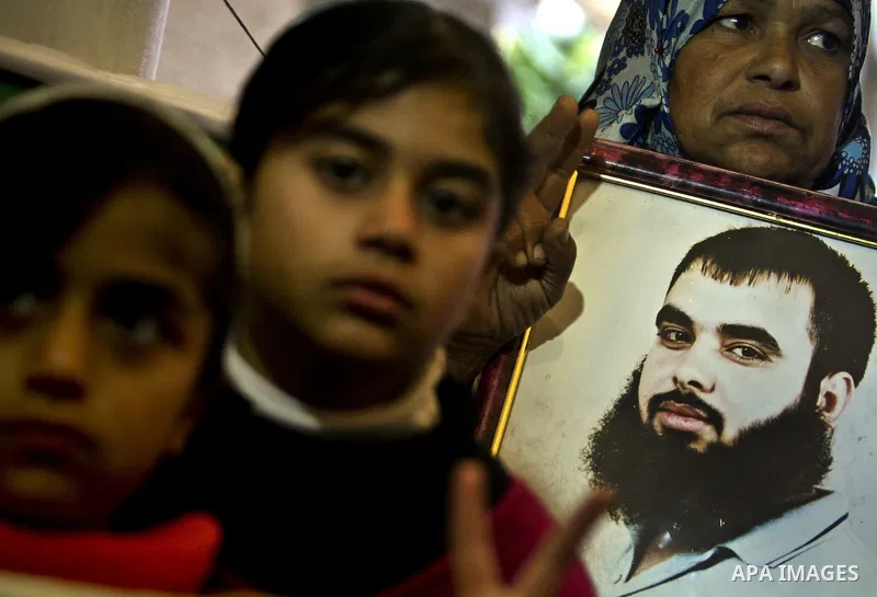 Palestinians hold pictures of their prisoned relatives in Israeli jails as they gather in a weekly activity calling for their liberty at the Red Cross headquarters in Gaza City, on Jan. 30, 2012. Photo by Ali Jadallah