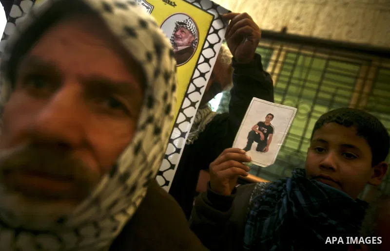 Palestinians hold pictures of their prisoned relatives in Israeli jails as they gather in a weekly activity calling for their liberty at the Red Cross headquarters in Gaza City, on Jan. 30, 2012. Photo by Ali Jadallah