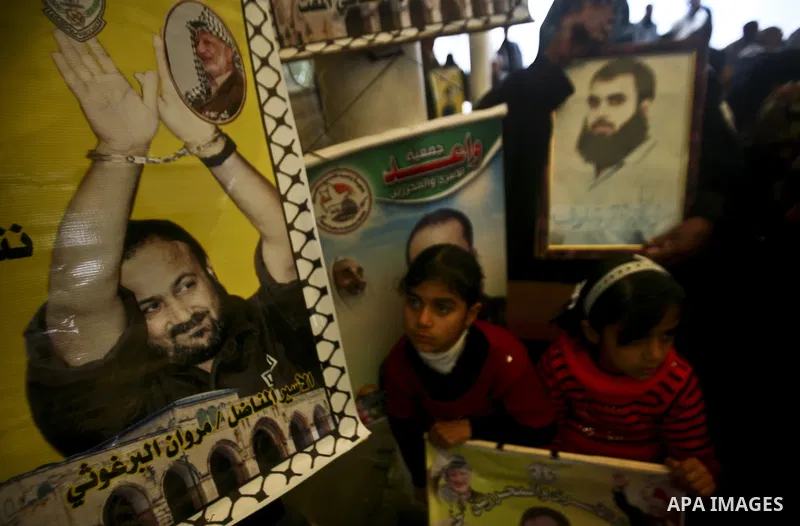 Palestinians hold pictures of their prisoned relatives in Israeli jails as they gather in a weekly activity calling for their liberty at the Red Cross headquarters in Gaza City, on Jan. 30, 2012. Photo by Ali Jadallah