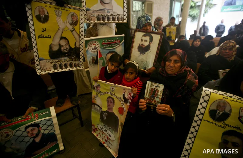 Palestinians hold pictures of their prisoned relatives in Israeli jails as they gather in a weekly activity calling for their liberty at the Red Cross headquarters in Gaza City, on Jan. 30, 2012. Photo by Ali Jadallah