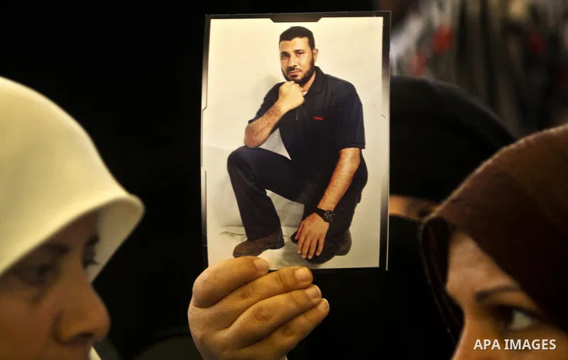 Palestinians hold pictures of their prisoned relatives in Israeli jails as they gather in a weekly activity calling for their liberty at the Red Cross headquarters in Gaza City, on Jan. 30, 2012. Photo by Ali Jadallah