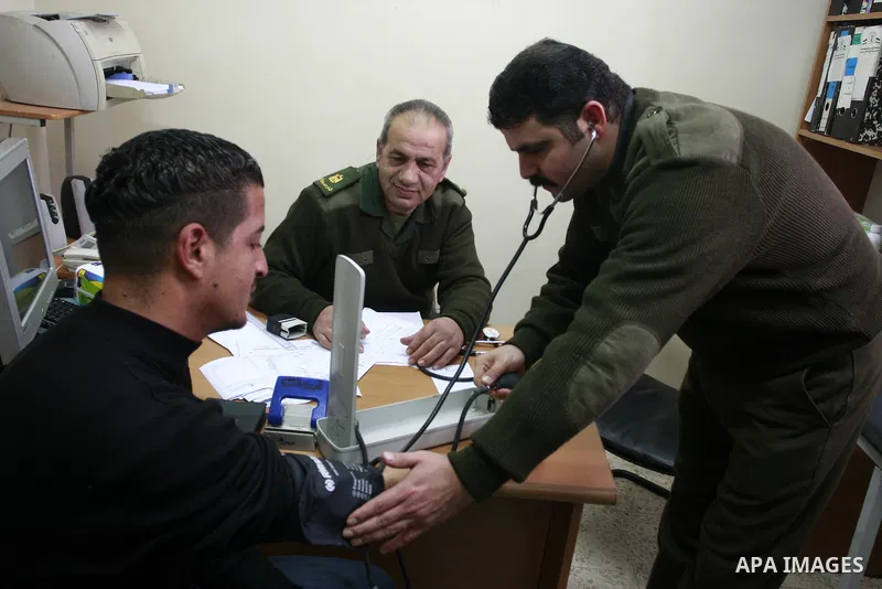Palestinian National Security forces help patients during working day the medical camp in his court in the West Bank city of Nablus, Jan. 30, 2012. Photo by Wagdi Eshtayah.
