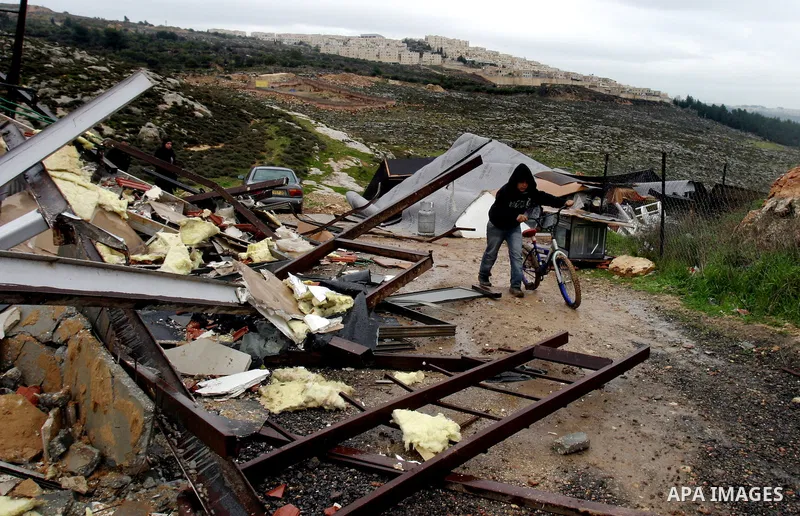 A Palestinian boy inspects the rubble of a home after it was demolished by Israeli bulldozers in the Arab east Jerusalem neighbourhood of Beit Hanina on January 30, 2012. Israel regularly demolishes homes in Arab east Je...