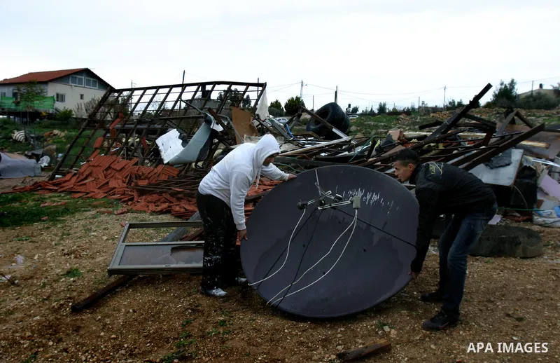Palestinian men salvage belongings after their home was was demolished by Israeli bulldozers in the Arab east Jerusalem neighbourhood of Beit Hanina on January 30, 2012. Israel regularly demolishes homes in Arab east Jer...