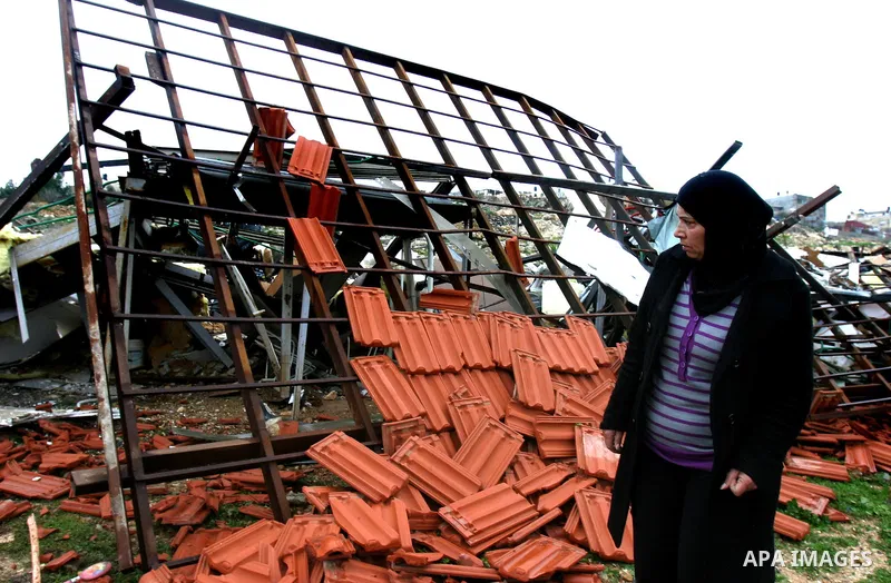 A Palestinian woman inspects the rubble of a home after it was demolished by Israeli bulldozers in the Arab east Jerusalem neighbourhood of Beit Hanina on January 30, 2012. Israel regularly demolishes homes in Arab east...