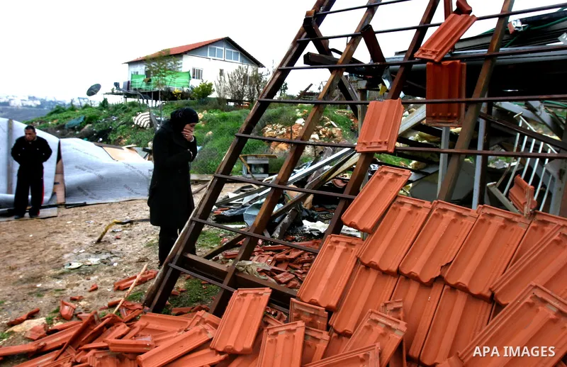A Palestinian woman inspects the rubble of a home after it was demolished by Israeli bulldozers in the Arab east Jerusalem neighbourhood of Beit Hanina on January 30, 2012. Israel regularly demolishes homes in Arab east...