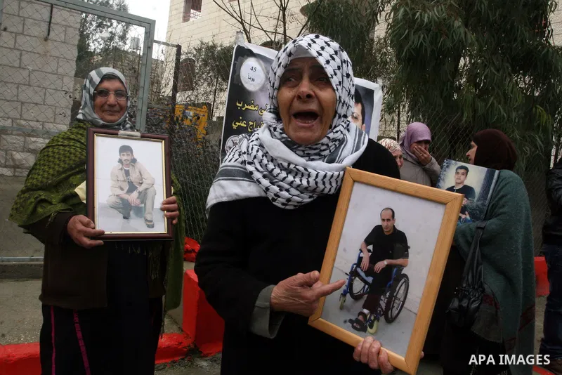 Palestinians take part in a demonstration calling for the release of Palestinian prisoners jailed in Israel, in front of the Red Cross offices in the West Bank town of Ramallah. Israeli authorities said Tuesday Jan. 31,...