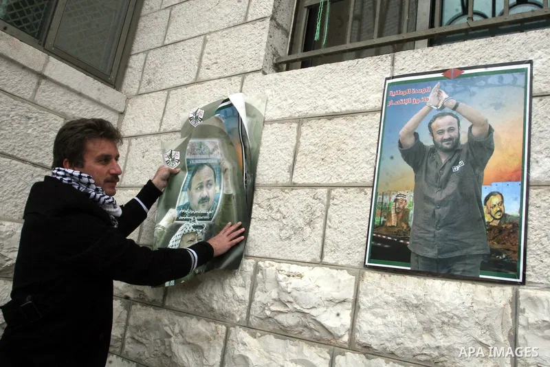 Palestinians take part in a demonstration calling for the release of Palestinian prisoners jailed in Israel, in front of the Red Cross offices in the West Bank town of Ramallah. Israeli authorities said Tuesday Jan. 31,...