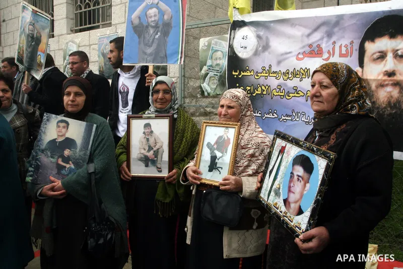 Palestinians take part in a demonstration calling for the release of Palestinian prisoners jailed in Israel, in front of the Red Cross offices in the West Bank town of Ramallah. Israeli authorities said Tuesday Jan. 31,...