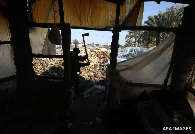 A Palestinian youth cuts firewood to sell to customers near the central Gaza Strip town of Deir al-Balah on January 31, 2012 as locals struggle against low winter temperatures amid daily power cuts and high fuel prices....