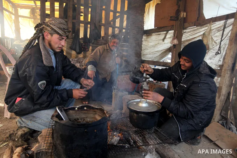 Palestinians heat as they cut firewood to sell to customers near the central Gaza Strip town of Deir al-Balah on January 31, 2012 as locals struggle against low winter temperatures amid daily power cuts and high fuel pri...