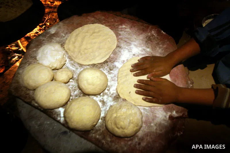 A Palestinian woman, from a Bedouin family, sits with her children preparing food during low winter temperatures inside her family's tent in Gaza's Zeitoun neighbourhood January 31, 2012. Photo by Mahmud Nassar