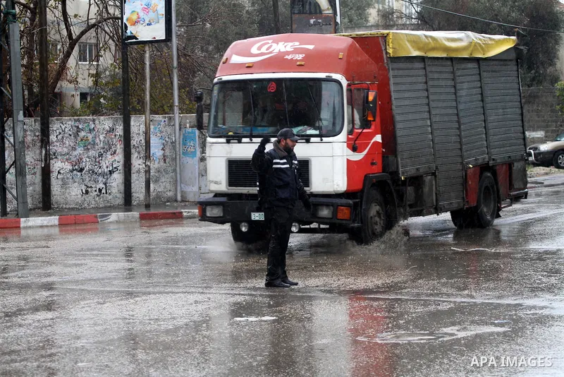 Palestinian policemen organize the traffic during the heavy rain of the winter, in the Gaza City, Feb. 01, 2012. Photo by Mohammed Asad