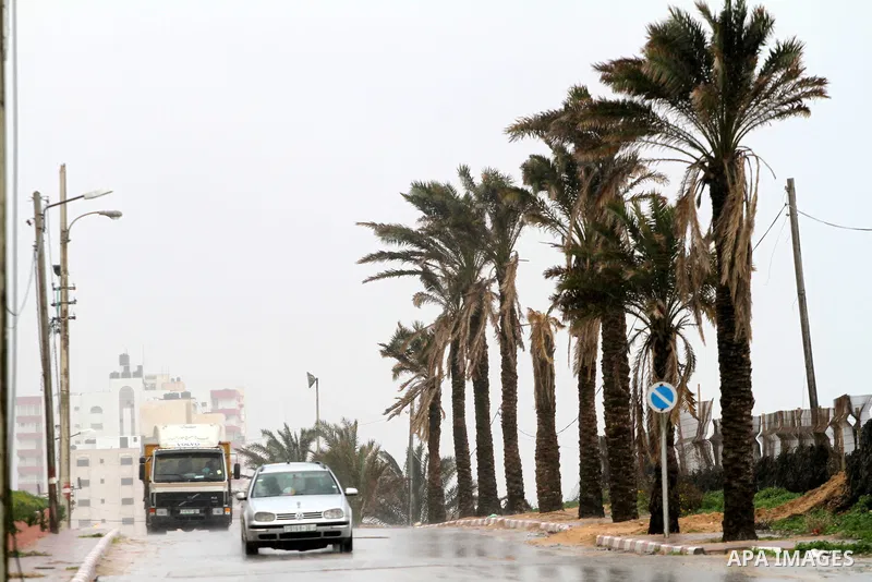 Palestinians drive their cars through a flooded street after heavy rain and cold winds, in the Gaza City, Feb. 01, 2012. Photo by Mohammed Asad