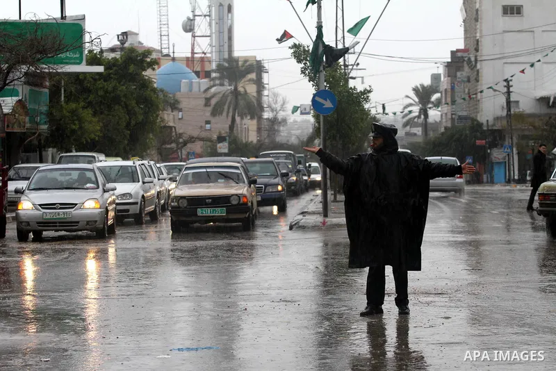 Palestinian policemen organize the traffic during the heavy rain of the winter, in the Gaza City, Feb. 01, 2012. Photo by Mohammed Asad