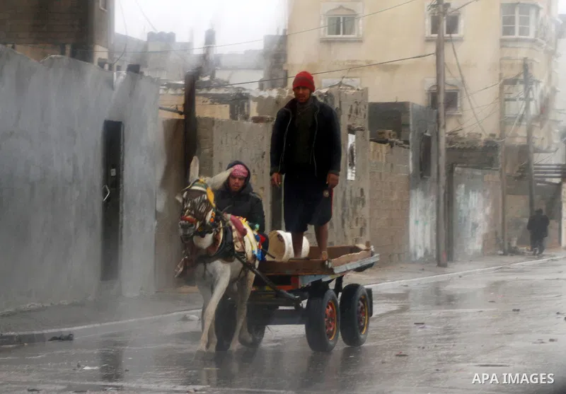 Palestinians walk in a street during the heavy rain of the winter, in the Gaza City, Feb. 01, 2012. Photo by Ashraf Amra